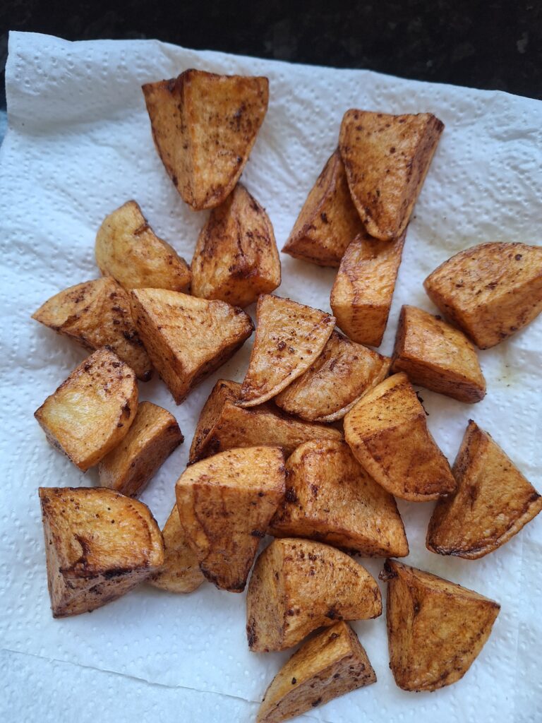 Fried potatoes draining off on kitchen roll