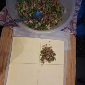 Keema applied to corner of puff pastry ready to fold