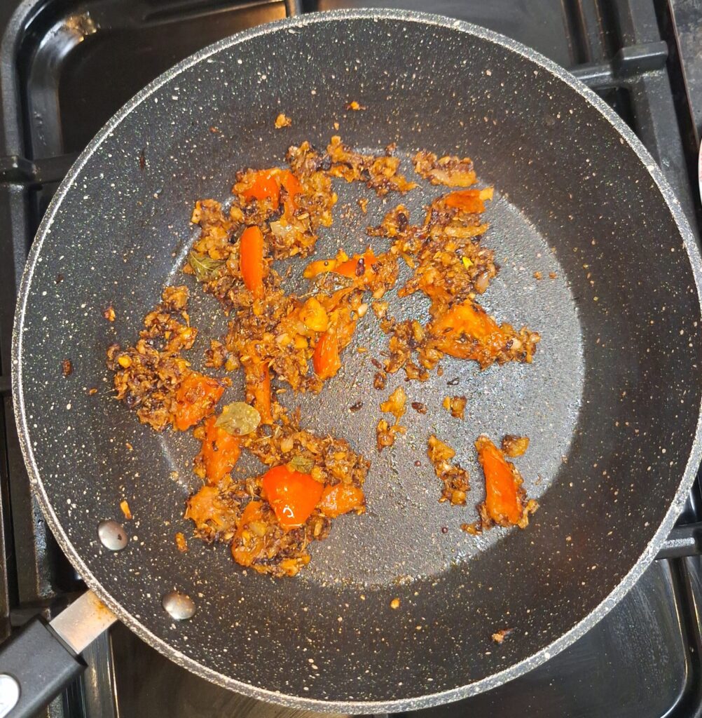 Tomatoes and spices added to pan