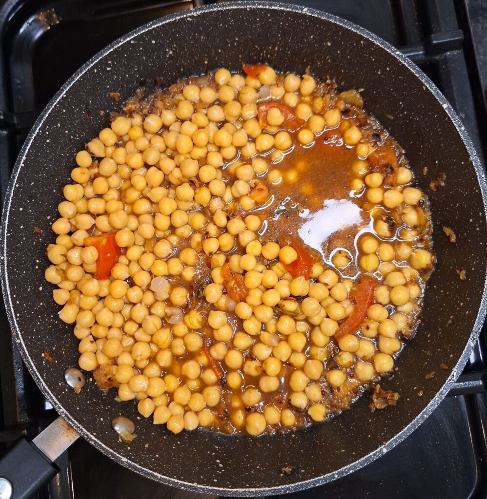 Water and chickpeas added to the pan