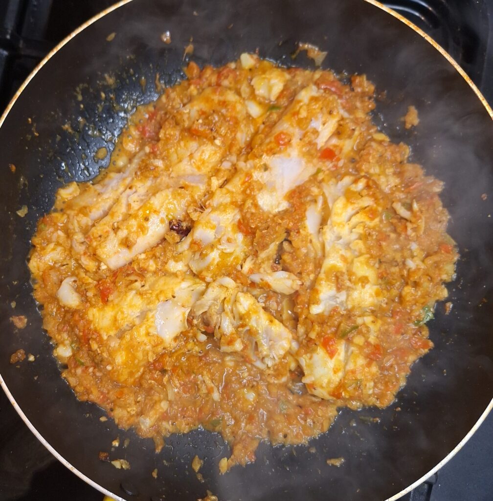 The fish starting to break up as it cooks