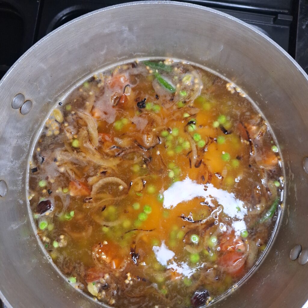 Rice, peas, green chillies added to pan
