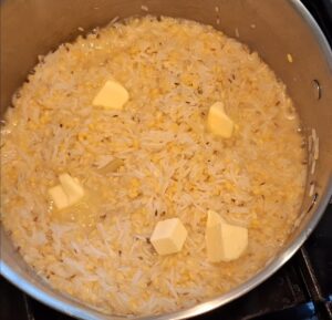 Adding butter to Khichdi before dham