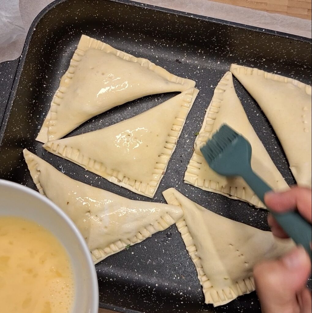 Keema pastries ready to bake, with egg wash applied