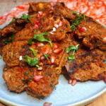 Juicy grilled lamb loin chops with a spice crust on a griddle