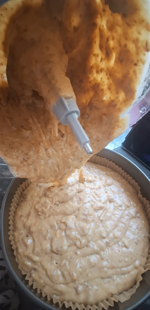 Scrape date and walnut cake mixture into tin