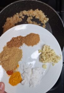Add spices to browned onions