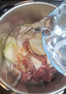 Add lamb, onions, spices and water to pressure cooker