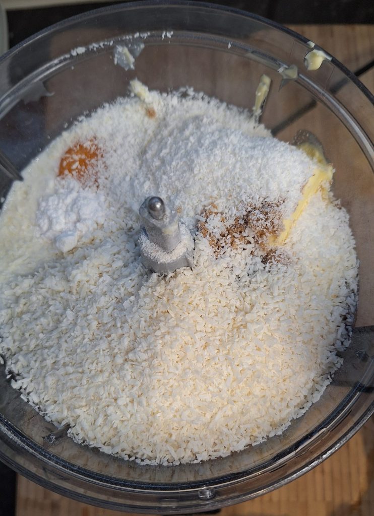 Moist coconut and jam cake topped with shredded coconut