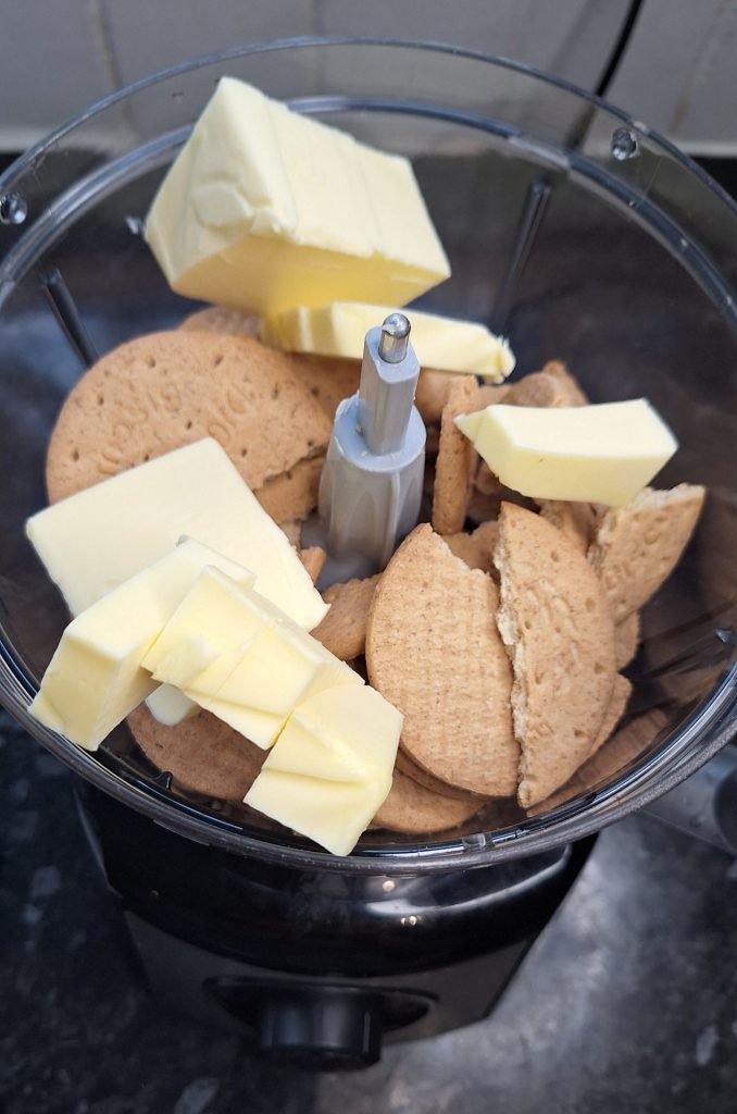 Add butter and digestive biscuits to food processor