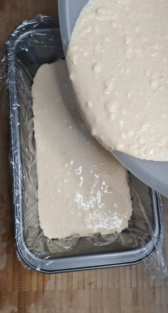 Pouring karak chai ice cream mixture into loaf tin
