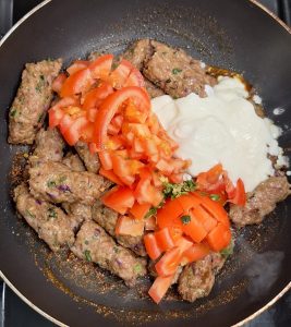 Add kebabs, tomatoes, green chillies and yoghurt to karahi