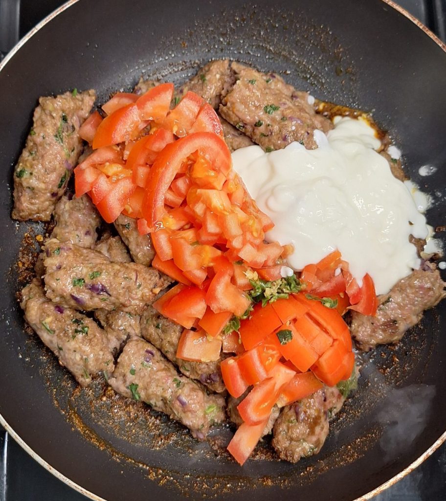 Add kebabs, tomatoes, green chillies and yoghurt to karahi