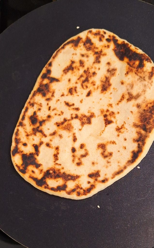 Flip naan over to cook other side