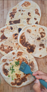 Brush garlic butter onto naan